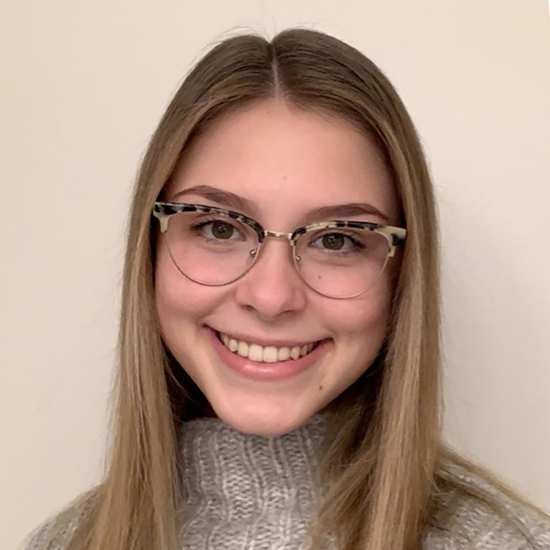 Headshot of Madelyn Smith with an eager smile and friendly brown eyes.