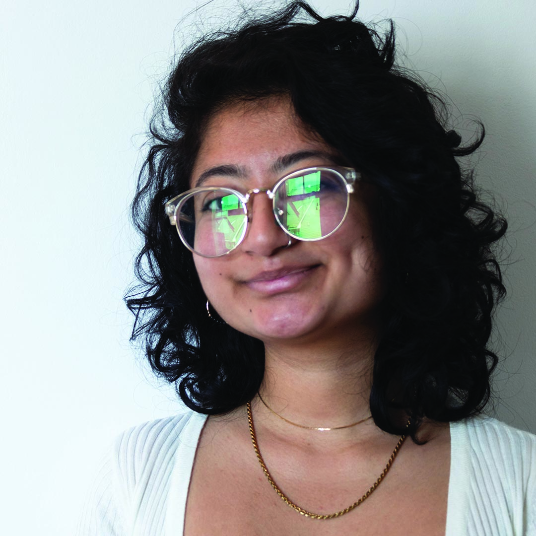 Headshot of Nirdishtha Raj Sapkota's face framed by glasses with brown eyes and a smile.