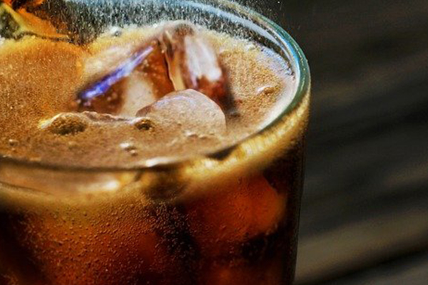 glass of fizzing soda and ice
