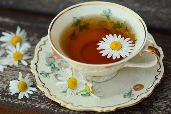 tea in cup on saucer with daisies